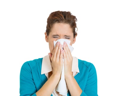 Closeup portrait miserable, sick teen woman with allergy, cold, blowing her nose with paper tissue, isolated white background. Human face expressions, reaction. Flu season, vaccination, prevention.