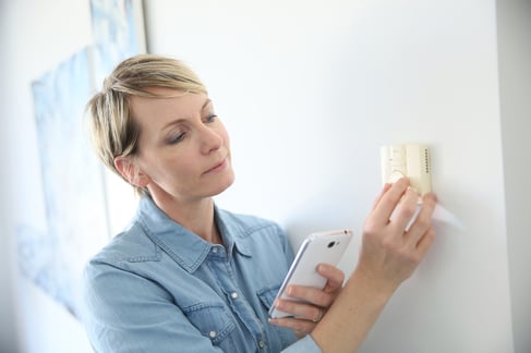 Woman porgramming indoor temperature with smartphone application